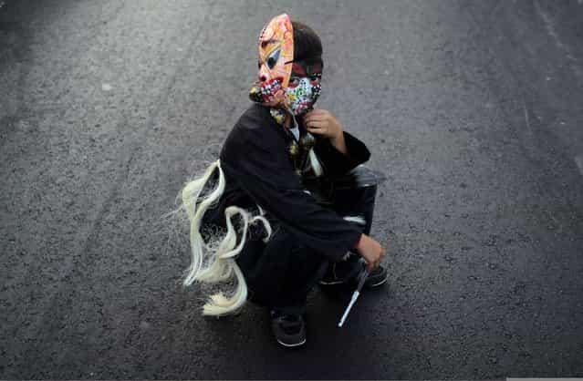 A boy with a mask and a painted face sits on a street as he takes part in an annual carnival called [Alegria por la Vida] (Joy for life) in Managua April 27, 2013. (Photo by Oswaldo Rivas/Reuters)