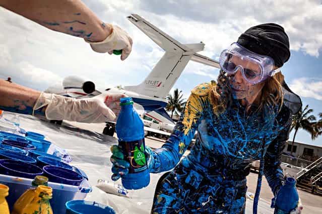Von Anhalt reloads a blue painting bottle. (Photo by Thomas Cordy/The Palm Beach Post)