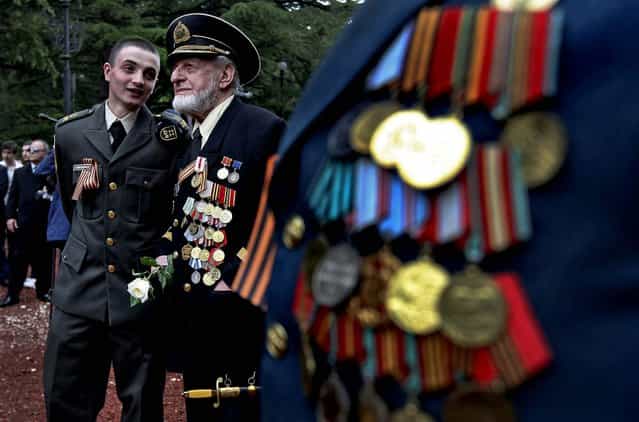 A Georgian military cadet speaks with a WW II veteran at a WW II memorial during Victory Day celebration in Tbilisi, as Georgia celebrates the 68th anniversary of the Soviet Union's victory over Nazi Germany. (Photo by Shakh Aivazov/Associated Press)