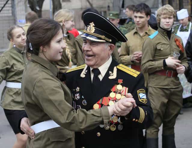 A World War Two veteran dances with a girl dressed in a Red Army uniform during a street performance ahead of Victory Day in the Russian Siberian city of Krasnoyarsk, May 7, 2013. (Photo by Ylia Naymushin/Reuters)
