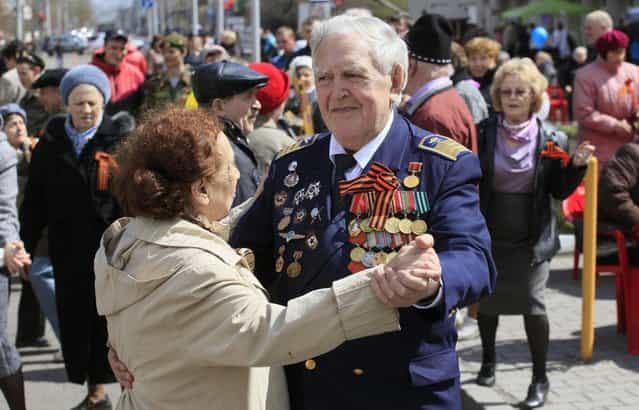 World War Two veteran Michael Tarskikh and his wife Irina, both 87, take part in a street dancing event on the eve of Victory Day in Russia's Siberian city of Krasnoyarsk, May 8, 2013. Tarskikh made 227 night flights on a Po-2 biplane across the front line for surveillance and photographing of Nazis target during World War Two in Belarus, Lithuania and East Prussia, took part in a storm of Konigsberg (Kaliningrad) and finished the war in the Baltic port of Danzig (Gdansk). Russia marks victory over Nazi Germany on May 9. (Photo by Ilya Naymushin/Reuters)