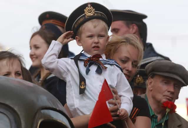 A child wearing Soviet Navy style uniform salutes during celebration of the Victory Day in St.Petersburg, Russia, Thursday, May 9, 2013. Russia is celebrating the anniversary of victory over Germany in WWII. (Photo by Dmitry Lovetsky/AP Photo)