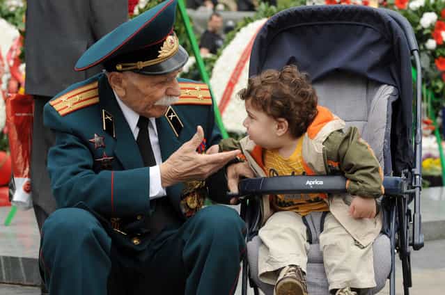 A World War II veteran speaks with a little child during Victory Day celebration in the Armenian capital Yerevan. Armenia as well as the other former Soviet republics celebrates the 1945 victory over Nazi Germany, the date of the Nazis' capitulation to the Soviet Union, which took place in the evening on May 8, 1945 (May 9 by Moscow Time), following the original capitulation Germany agreed earlier to the joint Allied forces on the Western Front. (Photo by Karen Minasyan/Getty Images)