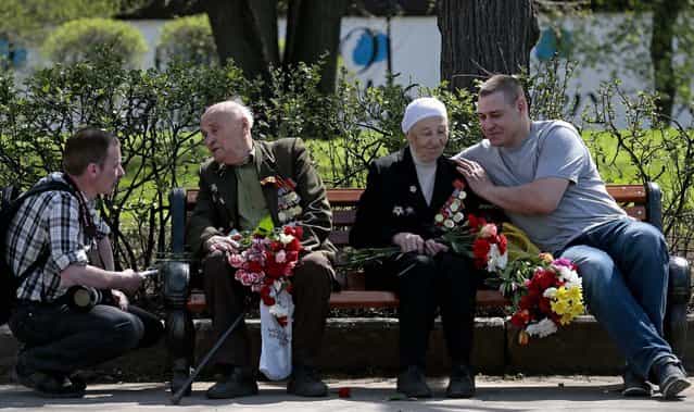 Two young men speak with WW II veterans Aleksakin Nikolay 90, second left, and Anna Parukhova, 90, second right, during Victory Day in Moscow's Gorky Park. (Photo by Mikhail Metzel/Associated Press)