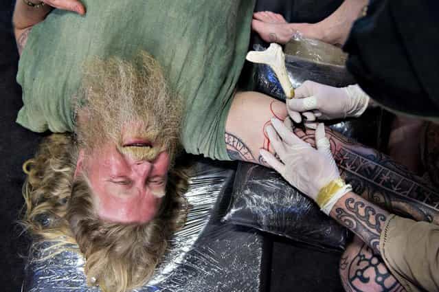 Kai Faust, right, not seen, of &quot;The Art of the Body&quot; decorates Par Andersson, of Sweden, using the Japanese Tebori technique, wherein the electrical pin is replaced by a tapered bamboo stick, during the third Copenhagen Ink Festival which opened Thursday May 9, 2013 in Copenhagen, Denmark, the biggest tattoo festival in Northern Europe. During the three days, 180 of the world's best and most celebrated national and international tattoo artists show the audience their skills in making art on the body and tattoo's on the audience. (Photo by Lars Krabbe/AP Photo)