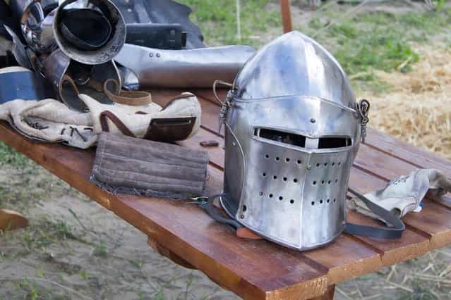 A helmet lays on a table during the [Battle of Nations] in Aigues-Mortes, southern France, Friday, May 10, 2013 where Middle Ages fans attend the historical medieval battle competition. The championship will be attended by 22 national teams, which is twice the number it was last year. The battle lasts until May 12. (Photo by Philippe Farjon/AP Photo)