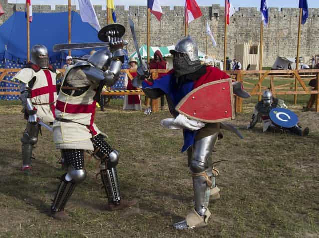 Members of the UK team, left, fight against a Czech Republic contestant during the [Battle of Nations] in Aigues-Mortes, southern France, Friday, May 10, 2013 where Middle Ages fans attend the historical medieval battle competition. The championship will be attended by 22 national teams, which is twice the number it was last year. The battle lasts until May 12.(Photo by Philippe Farjon/AP Photo)