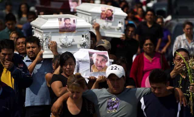Friends and family carry coffins containing the remains of victims of a gas tanker explosion in a funeral procession in Ecatepec, a Mexico City suburb, on May 8, 2013. A natural gas tanker truck lost control, hit a center divider and exploded on a highway lined by homes in the Mexico City suburb early Tuesday, killing at least 20 people and injuring nearly three dozen, authorities said. (Photo by Eduardo Verdugo/Associated Press)