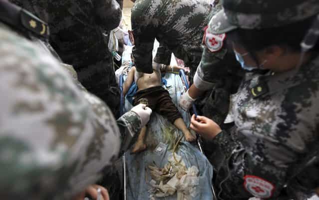 An injured child is treated by medical personnel after a landslide hit Lushan county, where a strong quake struck last month killing 196 people, in Ya'an, Sichuan province May 9, 2013. At least two people were killed and seven injured in the landslide on Thursday, according to Xinhua News Agency. (Photo by Reuters/China Daily)