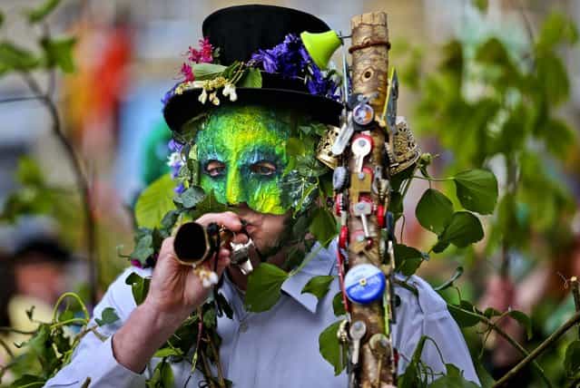 A performer with the Hal-an-Tow pageant blows his horn as part of the Helston Flora Day celebrations in Cornwall, England, on May 8, 2013. The annual event is one of the UK's oldest customs, celebrating the passing of Winter and the arrival of Spring. (Photo by Matt Cardy/Getty Images)