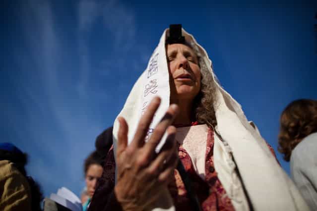 Members of the religious group [Women Of The Wall] hold a prayer service to mark the first day of the Jewish month of Sivan at the Western Wall on May 10, 2013 in Jerusalem, Israel. Thousands of ultra-Orthodox protestors clashed with Israeli police during the first monthly prayer service to be held by Women Of The Wall following the recent landmark ruling by Jerusalem District Court allowing women to wear prayer shawls at the Western Wall. (Photo by Uriel Sinai/Getty Images)