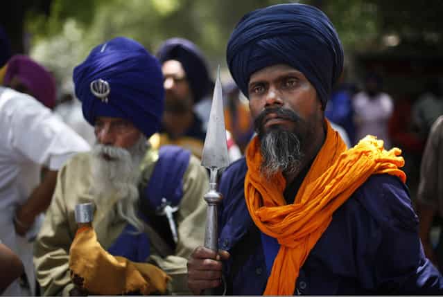 Indian Sikh Nihangs, part of an armed Sikh order, listen to a speaker, unseen, as they protest the acquittal of ruling Congress party leader Sajjan Kumar in New Delhi, India, Wednesday, May 8, 2013. An Indian court acquitted Kumar on April 30, of charges he incited mobs to kill Sikhs during the country's 1984 anti-Sikh riots. (Photo by Altaf Qadri/AP Photo)