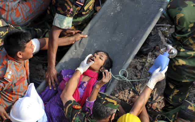 A survivor lies on a stretcher after being pulled out from the rubble of a building that collapsed near Dhaka, Bangladesh, on May 10, 2013. Rescue workers freed the woman buried for 17 days inside the wreckage of a garment factory building that collapsed, killing more than 1,000 people. Soldiers at the site said her name was Reshma and described her as being in remarkably good shape despite her ordeal. (Photo by Associated Press)