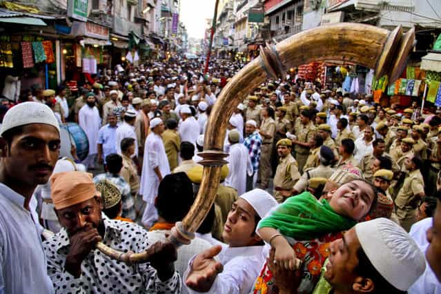 A pilgrim plays a horn during the flag hoisting ceremony to begin the Urs and Sufi festival in Ajmer, India, on May 7, 2013. The event attracts thousands of devotees to commemorate the 13th century death of their most famous saint, Moinuddin Chishti. (Photo by Deepak Sharma/Associated Press)