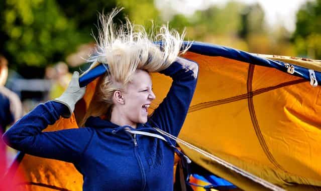 Mikaela Smith laughs and attempts to control some of her flying hair in front of the large fan used to begin inflating the envelope of the hot air balloon, Anonymous, Friday morning, May 10, 2013 at Greenpark Elementary School in Walla Walla, Wash. during the 39th annual Walla Walla Hot Air Balloon Stampede. (Photo by Matthew Zimmerman Banderas/AP Photo/Walla Walla Union-Bulletin)
