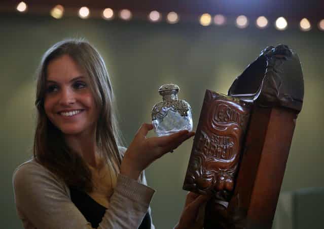 Lydia Stoker staff member at Lyon & Turnbull in Edinburgh, looks at a rare art nouveau carved perfume bottle stand valued at £8,000, designed by Henri Hamm to be auctioned on the 8th of May 2013. (Photo by David Cheskin/PA Wire)