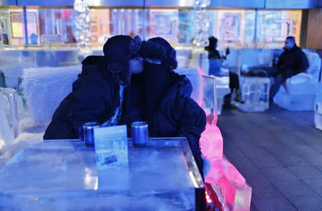 Honeymooner Ahmed, form Saudi Arabia who got married last week, kisses his veiled bride at Chillout cafe in Dubai May 12, 2013. Chillout, owned by UAE's Sharaf Group, is the first ice lounge in the Middle East, with temperatures set at –6 degrees Celsius (21 degrees Farenheit). The cafe, with its illuminated interiors, curtains, paintings and seating arrangements, is all made of carved ice and frozen sculptures. (Photo by Ahmed Jadallah/Reuters)