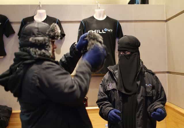 Ahmed, a Saudi Arabian, helps his newly-wed wife Nofa put on a fur hat at Chillout cafe in Dubai May 12, 2013. (Photo by Ahmed Jadallah/Reuters)