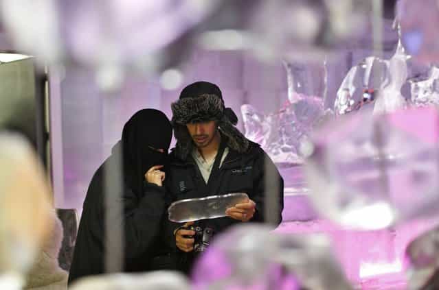 A Saudi Arabian couple inspect the menu at Chillout cafe in Dubai May 12, 2013. (Photo by Ahmed Jadallah/Reuters)