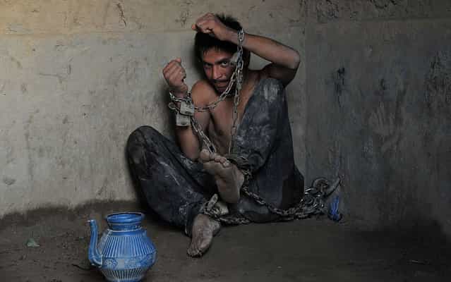 A mentally ill patient chained to a wall at the Mia Ali Baba holy shrine in the village of Samar Khel on the outskirts of Jalalabad, on May 16, 2013. At the Mia Ali Baba sanctuary the patients, presumed to be possessed by jinns (demons), are chained by the wrist inside, or in the open air to a tree, for 40 days. (Photo by Noorullah Shirzada/AFP Photo)