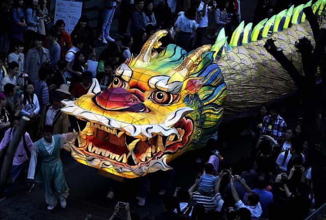 Buddhists carry a giant lantern in a parade through the streets of Seoul, South Korea, during the Lotus Lantern Festival to celebrate the upcoming birthday of Buddha, on May 12, 2013. (Photo by Ahn Young-joon/Associated Press)