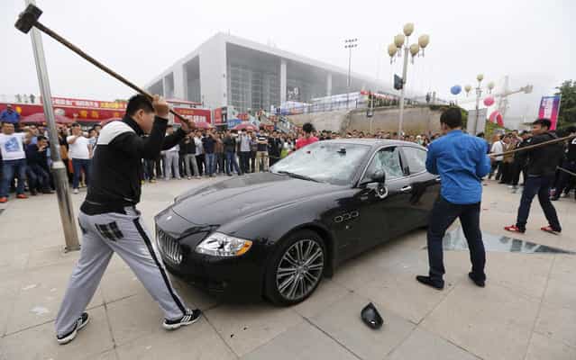 A man in China hired three people to destroy his Maserati – worth almost half a million dollars – because he was angry with the car dealer last Tuesday, May 14, 2013. The owner, identified only as Wang, paid the men to trash his $423,000 Maserati Quattroporte, worth N66.8million naira at the Qingdao International Auto Show. According to Car News China, Wang claimed the dealer had replaced faulty parts in his vehicle with used parts; he also accused both the dealer and an insurance company of fraud. (Photo by Reuters/Stringer)