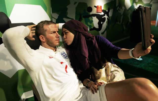 A woman poses with a wax figure of David Beckham at Madame Tussauds Wax Museum in Bangkok May 17, 2013. England's best known footballer David Beckham announced his retirement on Thursday after a career laden with trophies and glamour that had a worldwide impact that went way beyond soccer. (Photo by Chaiwat Subprasom/Reuters)