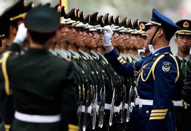 Chinese military officers use a piece of rope to line up honor guards as they prepare for a welcome ceremony for Greece's Prime Minister Antonis Samaras at the Great Hall of the People in Beijing, on May 16, 2013. (Photo by Andy Wong/Associated Press)