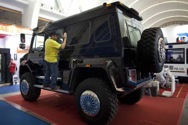 A man checks the interior of a Mercedes-Benz Unimog U5000 four-wheel-drive truck exhibited at a police equipment expo in Beijing, China, Wednesday, May 15, 2013. Chinese government spending on police, courts and other law enforcement to maintain social stability is projected to exceed outlays for national defense for the third year in a row this year. (Photo by Alexander F. Yuan/AP Photo)