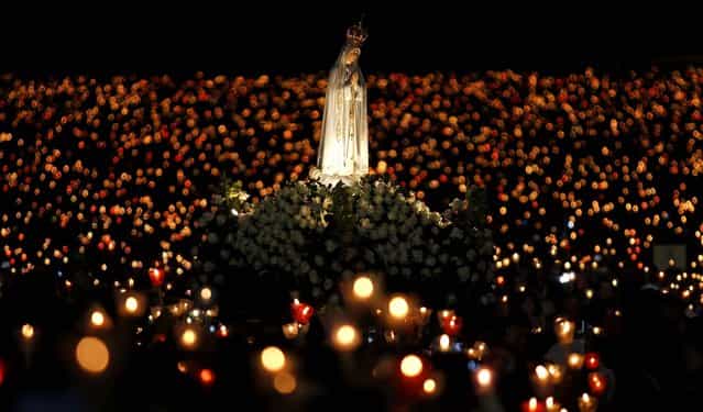 A statue of Our Lady of Fatima is carried during a candlelight vigil at the Fatima Sanctuary in Fatima, Portugal, on May 12, 2013. Every year on May 12 and 13, thousands of Catholic faithful pilgrimage to Fatima's Sanctuary where it is believed the Virgin Mary was witnessed by three shepherd children, Lucia, Jacinta and Francisco, on May 13, 1917. (Photo by Francisco Seco/Associated Press)