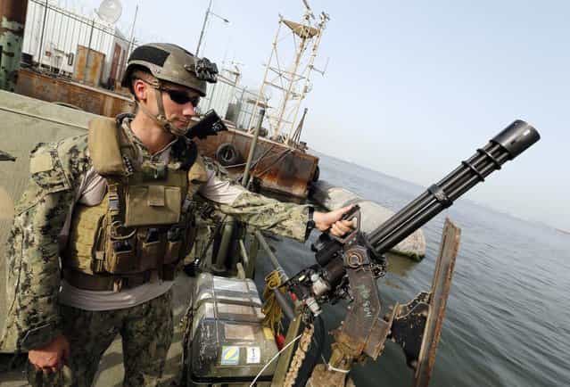 A U.S. Navy officer stands guard on Riverine Command Boat during a media tour ahead of the International Mine Countermeasures Exercise (IMCMEX), at the Bahrain Navy sea port in Manama May 12, 2013. Representatives from more than 40 nations will gather in Bahrain and waters of the Gulf region for the exercise, which is considered the largest exercise of its kind in the region. A British Royal Navy spokesperson said that it will be the first time for the British Royal Navy to head the entire exercise. (Photo by Hamad I Mohammed/Reuters)