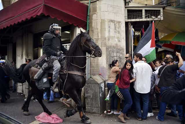 People move away from an Israeli policeman on a horse as Palestinians mark Nakba Day in Jerusalem, on May 15, 2013. Palestinians annually mark the [nakba], or [catastrophe] – the term they use to describe their defeat and displacement in the war that followed Israel's founding in 1948. (Photo by Mahmoud Illean/Associated Press)