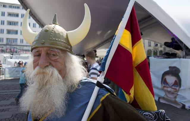 A Malmo resident dressed in a viking costume holds a composite [scandinavian] flag at a Eurovision public viewing area in downtown Malmo ahead of the finals of the 2013 Eurovision Song Contest on May 18, 2013. (Photo by John MacDougall/AFP Photo)