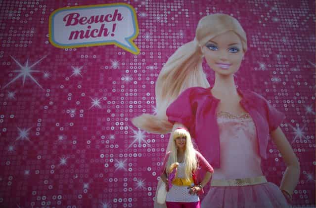 Model Ina Blaubeer poses with a Barbie doll in front a [Barbie Dreamhouse] of Mattel's Barbie dolls in Berlin, May 16, 2013. (Photo by Fabrizio Bensch/Reuters)