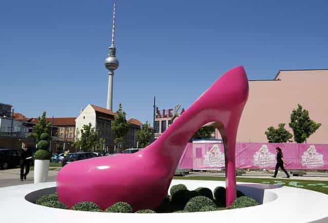 A giant shoe is pictured outside a life-size [Barbie Dreamhouse] of Mattel's Barbie dolls in Berlin, May 15, 2013. The life-sized house, covering about 1,400 square metres offers visitors to try on Barbie's clothes in her walk-in closet, tour her living room and her kitchen. (Photo by Fabrizio Bensch/Reuters)