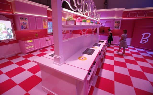 Girls watch the kitchen inside a life-size [Barbie Dreamhouse] of Mattel's Barbie dolls during a media tour in Berlin, May 15, 2013. (Photo by Fabrizio Bensch/Reuters)