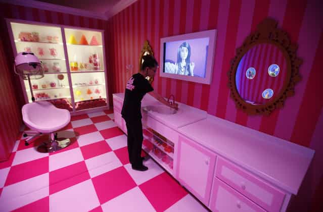 A staff poses for the photographer inside a life-size [Barbie Dreamhouse] of Mattel's barbie dolls in the bathroom during a media tour in Berlin, May 15, 2013. (Photo by Fabrizio Bensch/Reuters)
