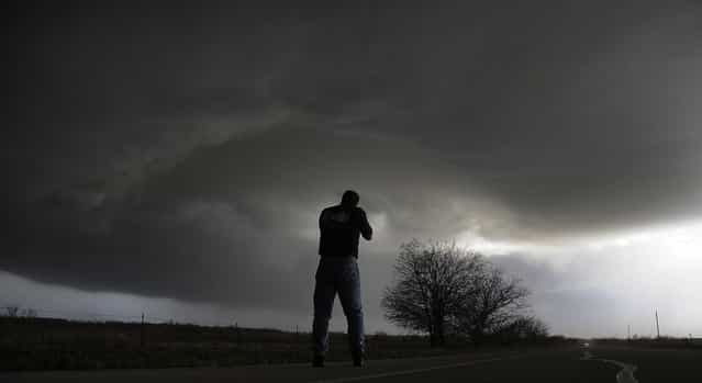 Storm chaser Brad Mack from Buena Park California videotapes a rotating supercell storm west of Newcastle, Texas April 9, 2013. (Photo by Gene Blevins/Reuters)