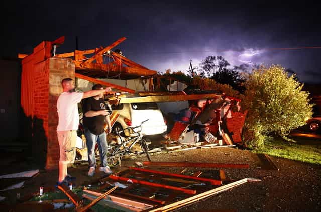 Derrek Grisham, left, points out neighborhood damage to storm chaser Travis Schafer after a tornado damaged his mother's house on Hyde Park Lane at Country Club Rd. in Cleburne, Texas,Wednesday night, May 15, 2013. Cleburne Mayor Scott Cain early Thursday declared a local disaster as schools canceled classes amid the destruction. (Photo by Tom Fox/AP Photo/The Dallas Morning News)