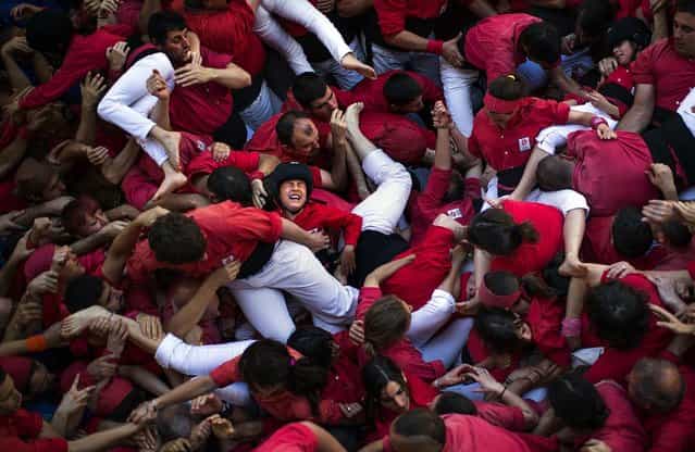 Members of the Castellers of Barcelona crowd together after the collapse of their [castell]. A few participants were slightly wounded after the collapse of the human tower and were taken to a hospital. (Photo by Emilio Morenatti/Associated Press)