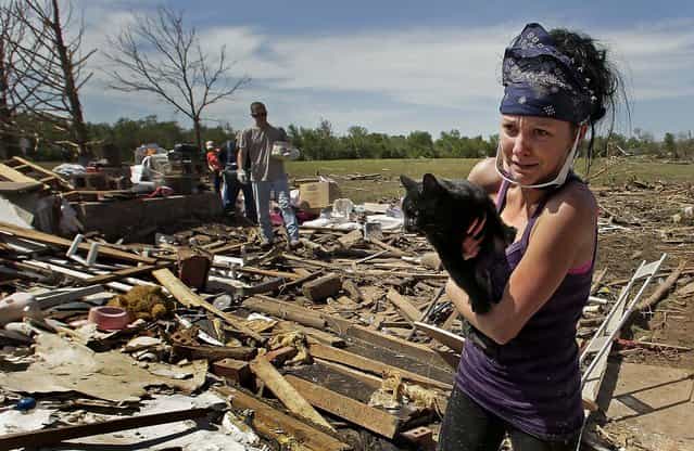 Brittany Brown rushes to get aid after finding her grandmother's cat [Kitty] which was buried in tornado rubble for two days. (Photo by Charlie Riedel/Associated Press)