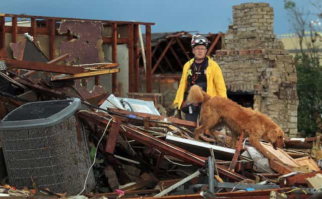 A member of Nebraska Task Force-1 and his search dog look through the remains of a in Moore on Tuesday. (Photo by Brad Loper/The Dallas Morning News)