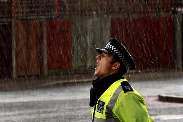 A police officer stands in a hail storm close to a crime scene where a soldier from Wellington Barracks was killed Wednesday. (Photo by Dan Kitwood/Getty Images)