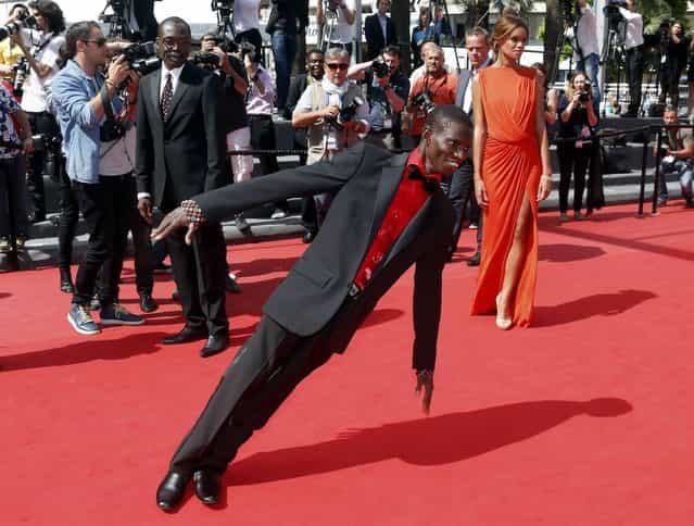 Cast member Souleymane Deme (C) performs on the red carpet as he arrives with director Mahamat-Saleh Haroun (L) and cast member Anais Monory for the screening of the film [Grigris] in competition during the 66th Cannes Film Festival in Cannes May 22, 2013. (Photo by Jean-Paul Pelissier/Reuters)