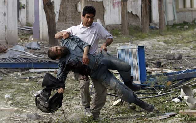 A wounded Afghan policeman is carried away from the site of an explosion in Kabul May 24, 2013. Several large explosions rocked a busy area in the centre of the Afghan capital, Kabul, on Friday with Reuters witnesses describing shooting in the area. (Photo by Omar Sobhani/Reuters)