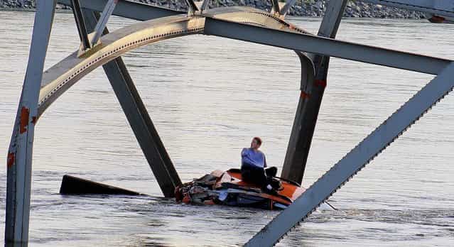 A man waits to be rescued after his car fell into the Skagit River after the collapse of the Interstate 5 bridge in Mount Vernon, Wash, on May 23, 2013. (Photo by Francisco Rodriguez/Associated Press)