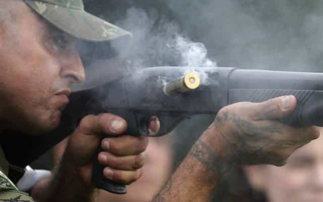 A Brazilian Navy member ejects spent cartridges while shooting rubber bullets during an exhibition of their operational capacity to combat terrorist attacks and riots ahead of the FIFA Confederations Cup and World Youth Day in Rio de Janeiro on May 27, 2013. (Photo by Ricardo Moraes/Reuters)