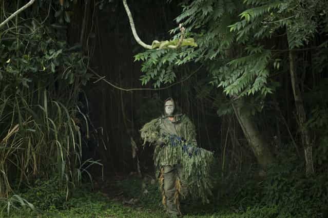 A Brazilian Navy sniper participates in a mock hostage rescue drill in Rio de Janeiro, Brazil, Monday, May 27, 2013. The Brazilian Navy conducted the drill in preparation for the Confederation Cup that runs from June 15–30. (Photo by Victor R. Caivano/AP Photo)