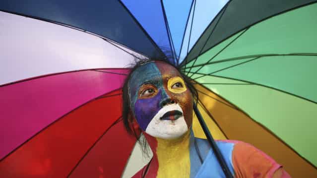 An Indonesian activist with painted face holds an parasol during a protest demanding equality for LGBTIQ (Lesbian, gay, bisexual, transgender and questioning) people in Medan, North Sumatra, Indonesia, Friday, May 31, 2012. Homosexuals and transgenders in the world's most populous Muslim country are often faced with discriminations and abuses. (Photo by Binsar Bakkara/AP Photo)