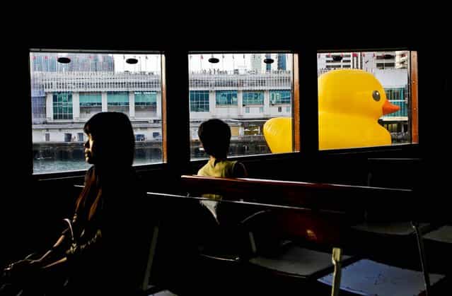 A giant rubber duck created by Dutch artist Florentijn Hofman is seen on May 29, 2013 from the window of a star ferry along Hong Kong's Victoria Habour. Since 2007, the 54-foot tall Rubber Duck has traveled to various cites including Osaka, Sydney, Sao Paulo and Amsterdam. (Photo by Vincent Yu/Associated Press)